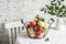 Fresh ripe apples in a metal vintage basket on the kitchen table on a light background