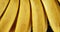 Fresh ripe bananas with water drops slowly rotating.