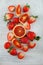 Fresh ripe blood oranges and strawberries, slices, rustic food photography on white wood plate