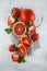 Fresh ripe blood oranges and strawberries, slices, rustic food photography on white wood plate