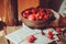 Fresh ripe cherries on plate with wrapped gift on wooden table