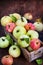 Fresh ripe colorful apples in wooden box on rustic background