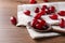 Fresh ripe dogwood berries, spoon and towel on wooden table, closeup. Space for text