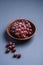 Fresh ripe grape berries in brown wooden bowl on blue grey minimal background