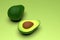Fresh ripe green avocado fruits, whole and cut in half, on light green