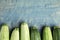 Fresh ripe green zucchinis on blue wooden table. Space for text