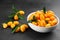 Fresh ripe kumquats in bowl on black table