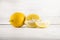 Fresh ripe lemons, slices, rustic food photography on white wood plate kitchen table