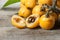 Fresh ripe loquat japanese medlar fruit with branch and leaf on wooden background