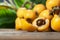 Fresh ripe loquat japanese medlar fruit with branch and leaf on wooden background