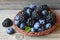 Fresh ripe organic blackberries and blueberries in a basket on old wooden table.Healthy eating,vegan food or diet concept.