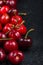 Fresh ripe organic cherries on black border background