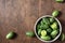 Fresh ripe organic cucamelons or Melothria scarba mini cucumbers in a bowl on wooden table. Top view