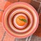 Fresh ripe organic mandarin with a green leaf on a brightly colored striped plate on wool plaid.Top view, flat lay.