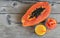 Fresh ripe organic papaya tropical fruit cut in half,sliced and papaya juice in a glass jar on old wooden background.