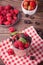 Fresh ripe organic raspberry, strawberries and black currant in tin can and plate on rustic wooden table