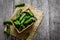 Fresh ripe organic small gherkin cucumbers in basket on wooden table