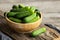 Fresh ripe organic small gherkin cucumbers in bowl on wooden table