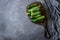 Fresh ripe organic small gherkin cucumbers on cutting board on dark rustic table