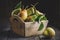 Fresh ripe pears in a wooden crate on table.