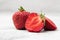 Fresh ripe perfect pieces strawberry on white marble background. Fresh strawberry as texture background. Natural food backdrop