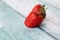 Fresh ripe perfect strawberry on blue wooden background. Fresh strawberry isolated. Natural food backdrop with red berries.