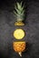 Fresh ripe pineapple cross sections on dark background, vertical