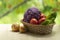 Fresh ripe purple cauliflower, onion, red tomatoes and green cucumber in basket. Healthy food on table on defocus autumn