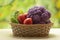 Fresh ripe purple cauliflower, red tomatoes and green cucumber in basket. Healthy food on table on defocus autumn