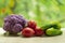 Fresh ripe purple cauliflower, red tomatoes and green cucumber. Healthy food on table on defocus autumn background.