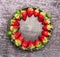 Fresh ripe strawberries in plate on gray wooden background, food frame, top view