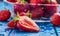 Fresh ripe strawberries washed with water on blue table