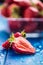 Fresh ripe strawberries washed with water on blue table