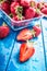 Fresh ripe strawberries washed with water on blue table