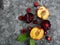 Fresh ripe summer berries and fruits, peaches, apricots, cherry and plum in a round plate on the table