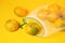 Fresh ripe tangerines in reusable eco friendly mesh bag on yellow background. Top view. Zero waste shopping concept