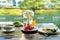 Fresh romantic breakfast table next to window with bread, fruit, juice, milk, noodle soup