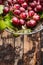 Fresh rose grapes with green leaves on dark wooden background, top view