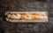 Fresh rosy baguettes on a dark wooden retro background. Top view, copy space