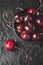 Fresh ruby cherries on black slate background. Flatlay. Dark moody close up still life