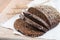 fresh rustic wholemeal rye bread, sliced on a wooden board, closeup.