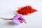 Fresh saffron flower on a background of dried saffron on a white table