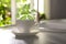 Fresh sage leaves falling into cup of aromatic tea on white table indoors