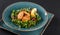 Fresh salad with arugula, spinach, avocado and vegetable cutlets with herbs in plate over dark background. Healthy vegan food,