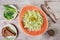 Fresh salad with cabbage, green peas, onions and greens on wooden background close up. Healthy food, vegan.