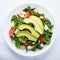 Fresh salad with chicken, tomatoes, spinach and avocado on white background top view