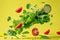 Fresh salad ingredients on yellow background lettuce, tomato, spinach, cucumber, green sprouts