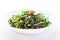 Fresh salad with mixed greens (arugula, mesclun, mache) on white wooden background close up.