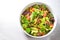 Fresh salad of mixed lettuce, orange, grapefruit, salami and pine nuts in a large bowl on a white painted table with copy space,