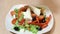 Fresh salad with olive oil isolated on white background, pouring salad dressing into cutting vegetables, organic food